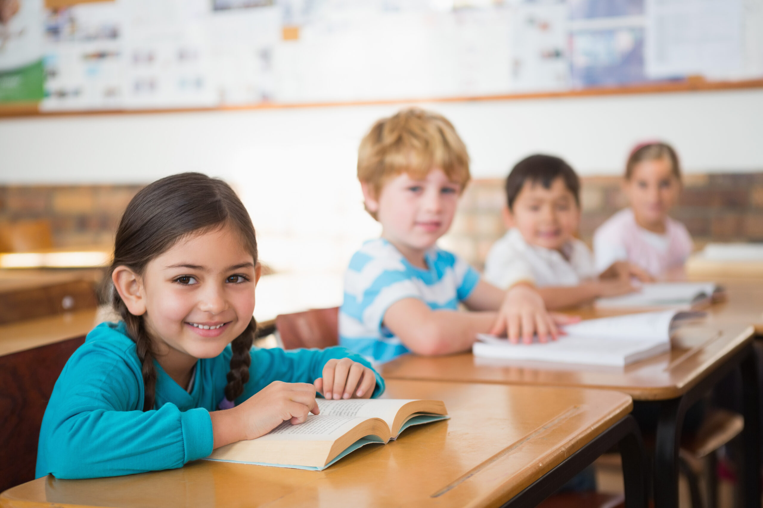 Pupils sitting in classroom reading books at the elementary school