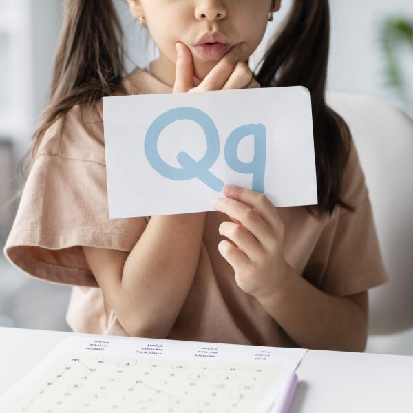 little-girl-holding-paper-with-letter-it-speech-therapy
